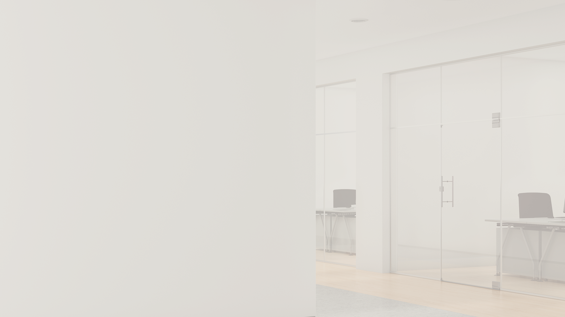 Washed-out photo of a bright office with glass doors and desks